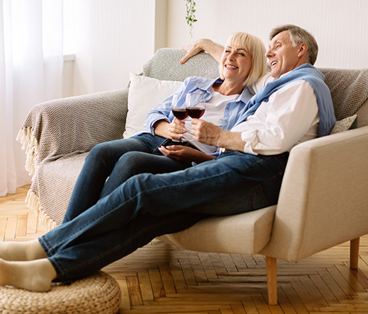 smiling retired couple on couch with wine different retirement planning strategies white bear lake mn